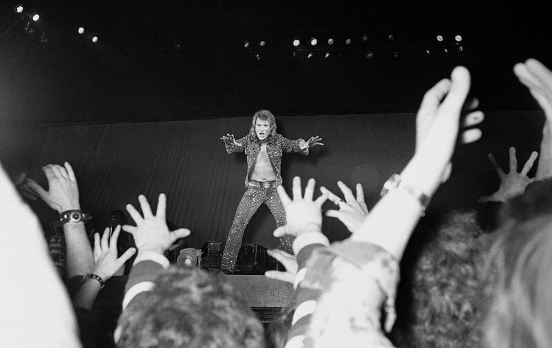 FILE - In this Sept.27 1971 file photo, French rock singer Johnny Hallyday performs at the Palais des Sports in Paris. The French president's office says Hallyday, who packed sports stadiums for decades, has died at age 74.  (AP Photo/Cardenas, File)