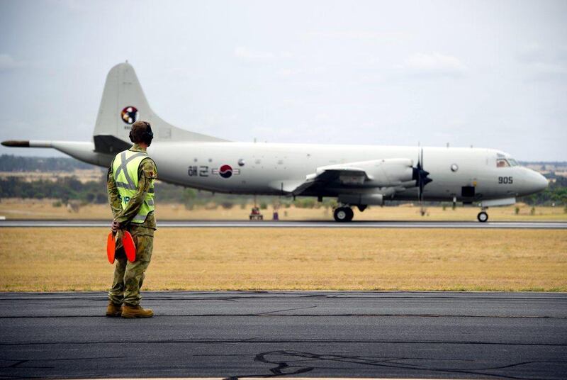 A  Korean Navy  P3-C Orion aircraft is watched by an official as it arrives at the Royal Australian Air Force (RAAF) Base Pearce, located north of Perth, to participate in the search for missing Malaysia Airlines Flight MH370. Severe weather on Thursday halted an air and sea search for a Malaysia Airlines passenger jet presumed crashed in the southern Indian Ocean. Australian Defence Force/Handout via Reuters March 27
