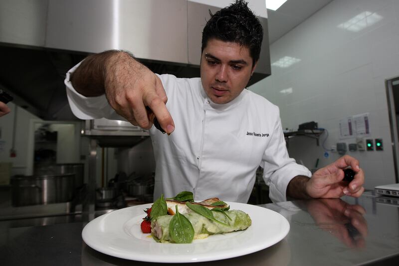 
DUBAI , UNITED ARAB EMIRATES Ð May 27 , 2013 : Jose Vicente Jorge , Chef making Roast fillet of seabass with wild mushrooms , spinach and ricotta cannelloni dish in the kitchen of Vogue Cafe at Dubai Mall in Dubai.  ( Pawan Singh / The National ) For Arts & Life. Story by Rebecca McLaughlin 
