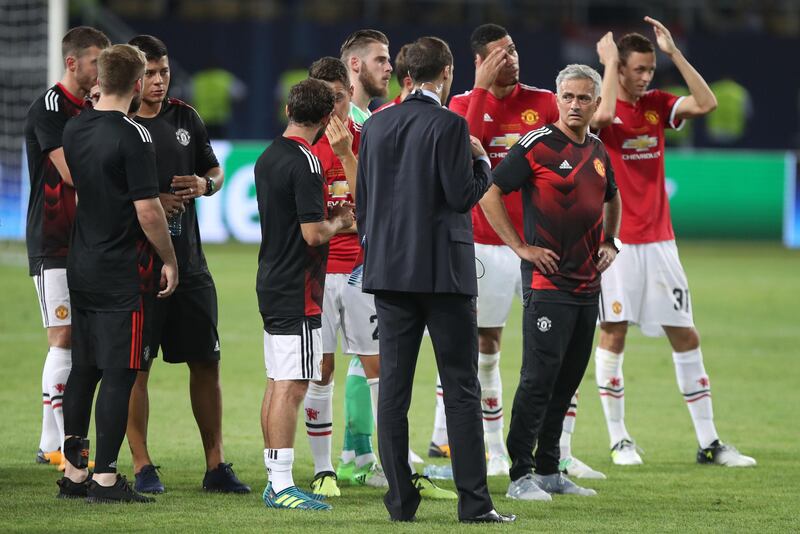 Manchester United manager Jose Mourinho and his players look dejected as Real Madrid players lift the trophy. Nick Potts / PA