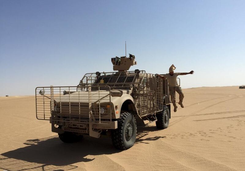 An Emirati soldier jumps from an armoured vehicle in Marib. Noah Browning / Reuters