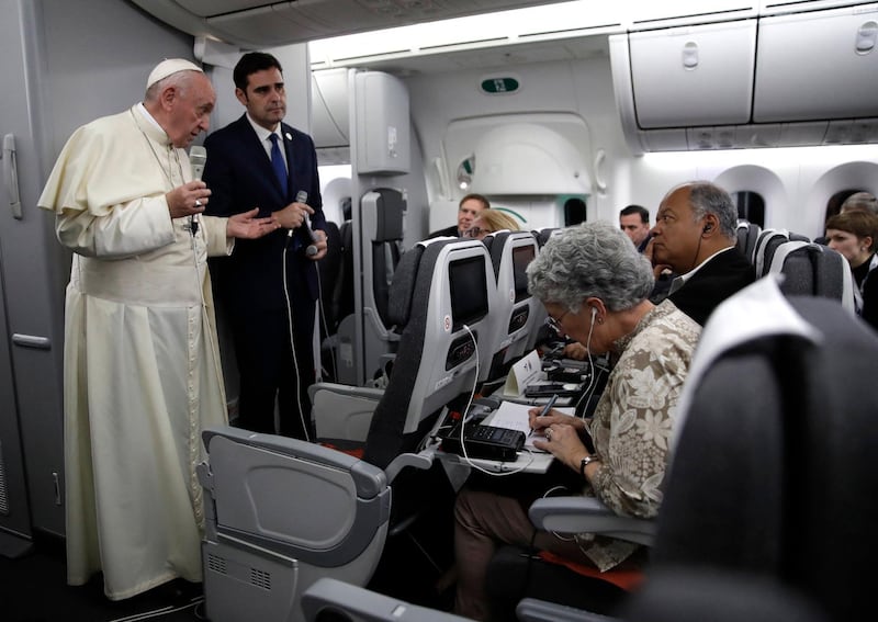 Pope Francis, flanked by Vatican spokesman Alessandro Gisotti (R) anwers journalists questions in the plane following the take off from Panama City on January 27, 2019 after participating in World Youth Day. (Photo by Alessandra TARANTINO / POOL / AFP)