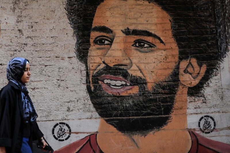 A girl walks in front of a mural depicting Liverpool player Mohamed Salah in Hihya city, in Sharqia Governorate, north of Cairo, Egypt. Reuters