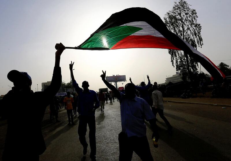 Sudanese demonstrators wave their national flag. Reuters