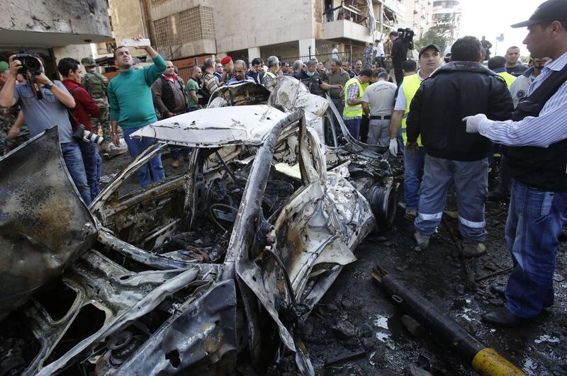 Rescue teams, journalists and security forces gather at the scene of a car bomb explosion in Bir Hassan neighbourhood in southern Beirut on November 19, 2013. A powerful blast in the Lebanese capital killed at least 10 people outside the Iranian embassy, police and security sources told AFP. AFP PHOTO/ANWAR AMRO