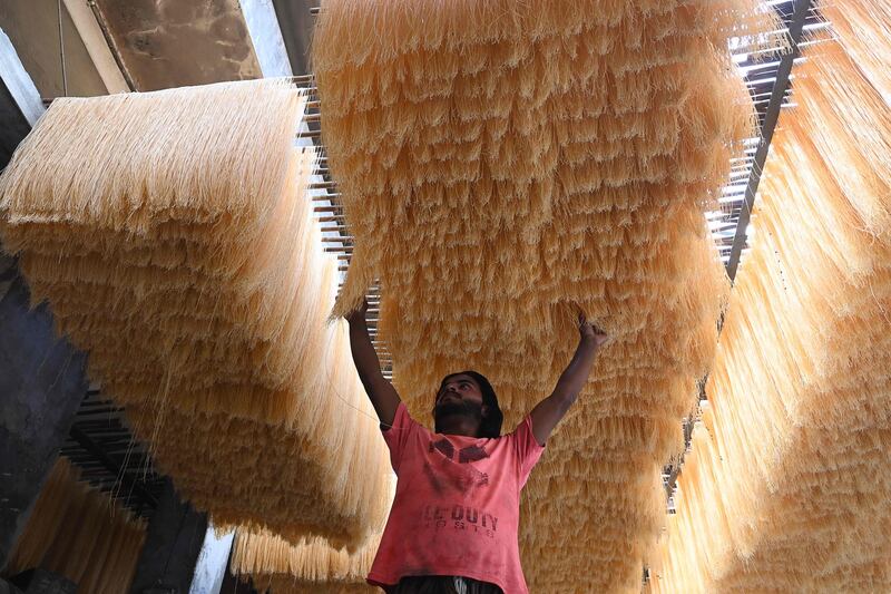 A worker in Lahore, Pakistan, dries vermicelli used to make a traditional sweet dish popular during Ramadan. EPA