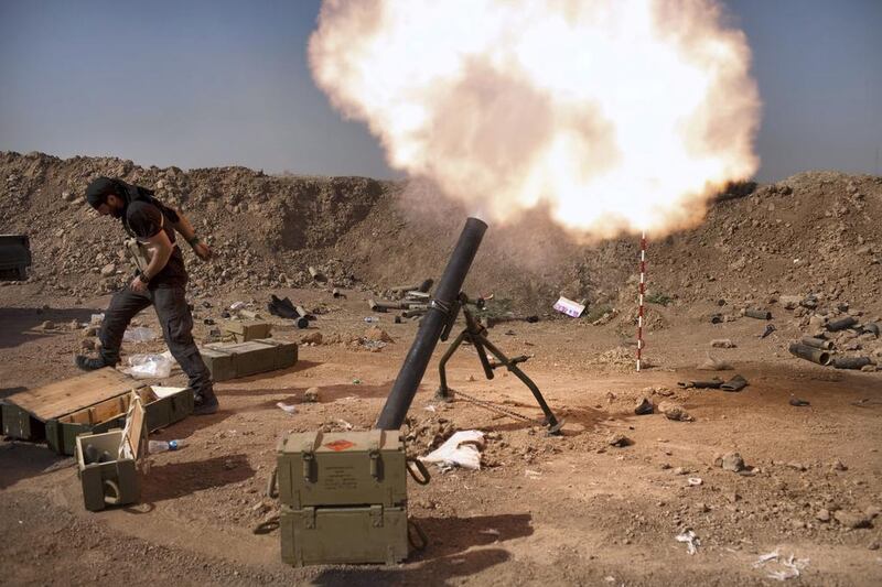 An Iraqi militia fighter from Shiite cleric Moqtada Al Sadr's Saraya Al Salam, fires a mortar during heavy clashes with Islamic State in Iraq and the Levant fighters in Tuz Khurmatu in Salaheddin province about 88 kilometres south of Kirkuk on August 31. Iraqi forces broke through to the ISIL-besieged Shiite town of Amerli, where thousands of people have been trapped for more than two months with dwindling food and water supplies. AFP Photo 

