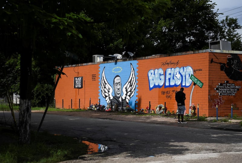 A man stands next to a mural of George Floyd in Houston, Texas. Reuters