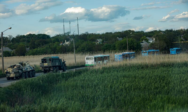 Russian militrary vehicles escort buses carrying Ukrainian troops from the Azovstal steel plant. EPA 