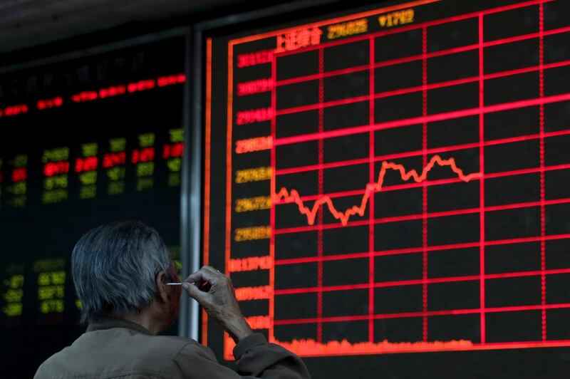 An investor digs his ear while monitoring stock prices at a brokerage in Beijing on Wednesday, Sept. 25, 2019. Stocks skidded in Asia on Wednesday after Democrats in the U.S. House of Representatives said they were considered launching an impeachment probe of President Donald Trump. (AP Photo/Ng Han Guan)