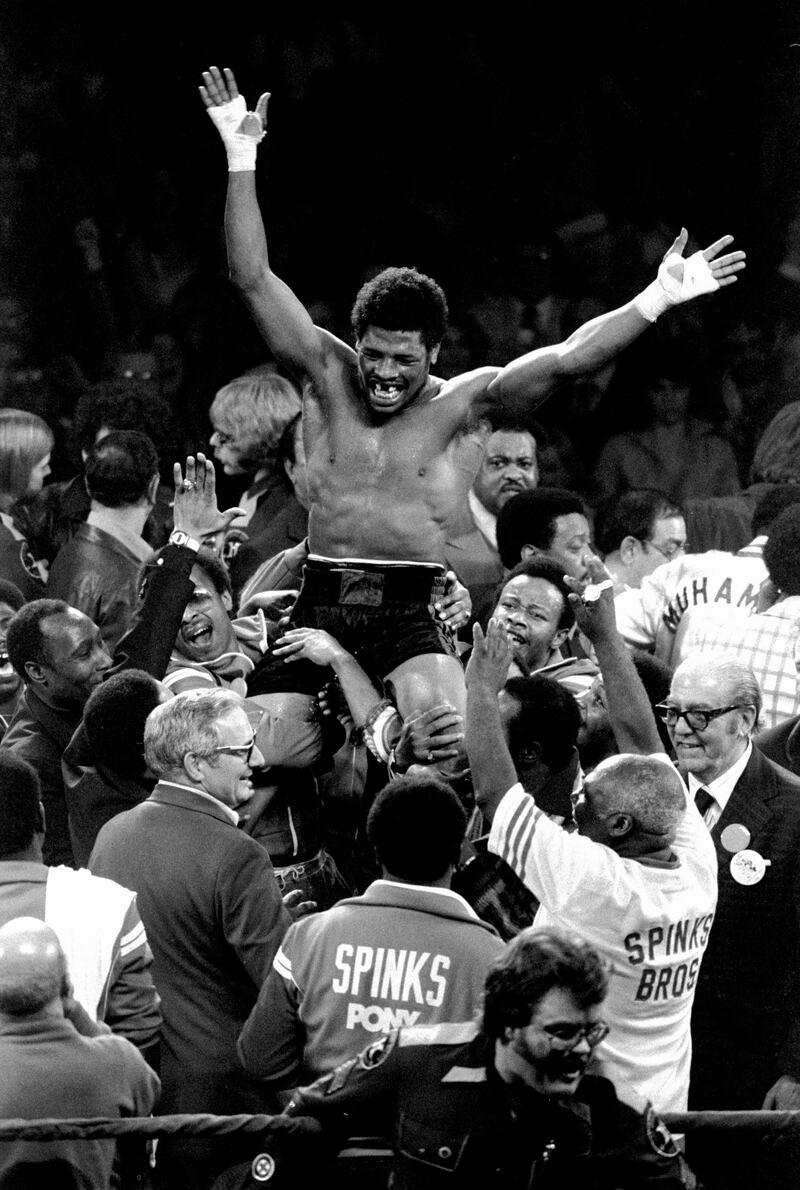 Leon Spinks celebrates as his entourage holds him aloft after his 15-round split decision victory over world heavyweight boxing champion Muhammad Ali. AP