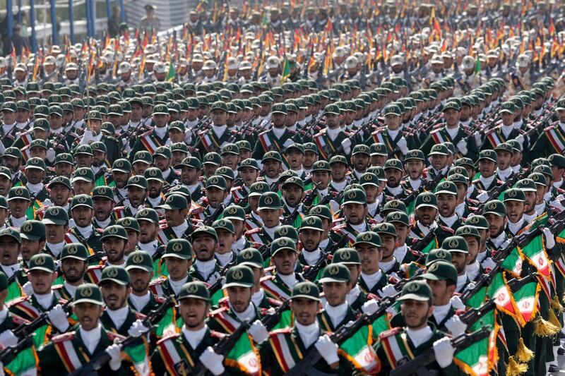 FILE - In this Sept. 21, 2012 photo, Iran's Revolutionary Guard troops march during a military parade commemorating the anniversary of start of the 1980-88 Iraq-Iran war, in front of the shrine of the late revolutionary founder Ayatollah Khomeini, just outside Tehran, Iran. Supreme Leader Ayatollah Ali Khamenei has ordered the Revolutionary Guard to loosen its hold on the economy, the country's defense minister says, raising the possibility that the paramilitary organization might privatize some of its vast holdings. (AP Photo/Vahid Salemi, File)