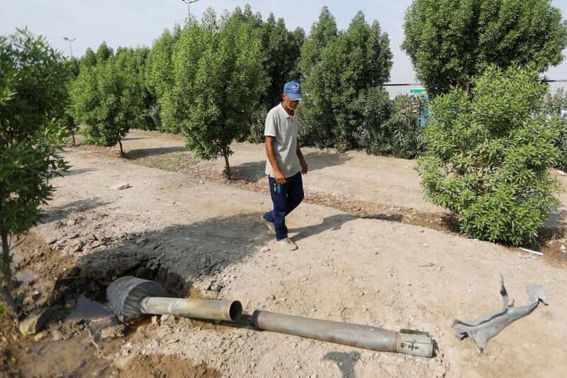 A man looks at a rocket that flew away after a weapons depot of an Iraqi militia group caught fire, in Baghdad, Iraq.  REUTERS