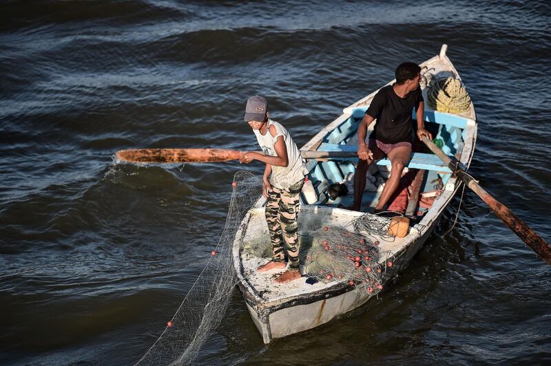 An Egyptian boy throws out his fishing net in the Suez Canal near Ismailia city.  AFP