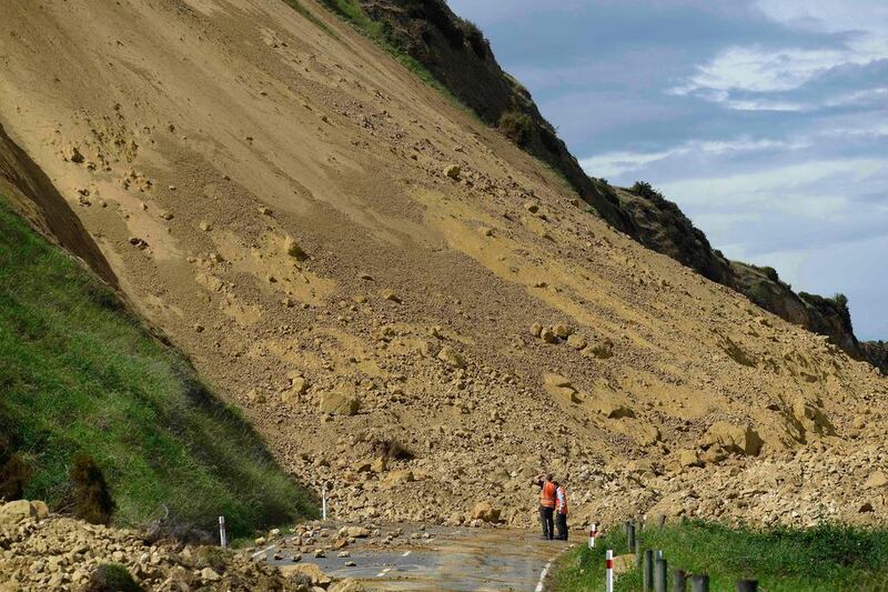 Emergency services officers inspect the damage caused to Rotherham Road near Waiau town, 90km to the south of Kaikoura, after an earthquake hit New Zealand just after midnight on Monday. Rescue efforts after the devastating earthquake intensified as a fleet of international warships began arriving in the disaster zone. AFP