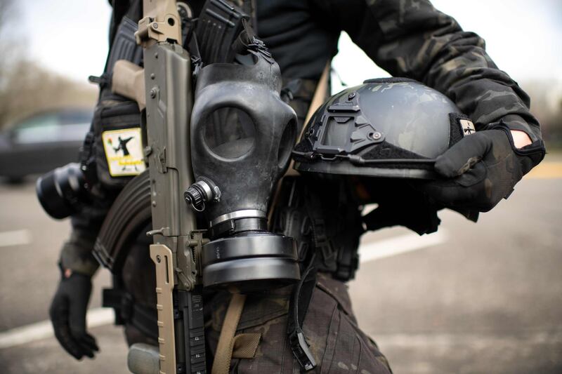 (FILES) In this file photo taken on January 17, 2021 a member of the Boogaloo Boys stands armed with an assault rifle, gas mask and combat helmet outside of the Oregon State Capitol building in Salem, during a nationwide protest called by anti-government and far-right groups supporting US President Donald Trump and his claim of electoral fraud in the November 3 presidential election. The US Department of Homeland Security declared a nationwide terrorism alert January 27, 2021, citing the potential threat from domestic anti-government extremists after Joe Biden was sworn in as president. / AFP / Mathieu Lewis-Rolland
