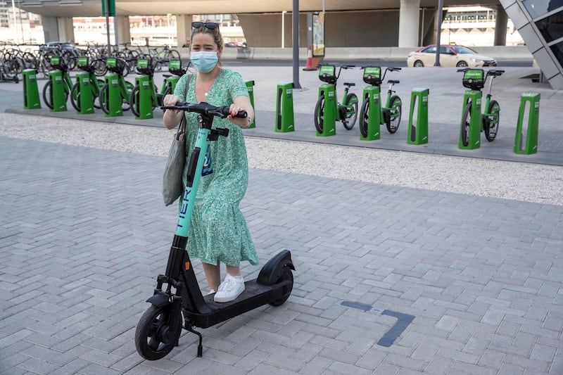 DUBAI, UNITED ARAB EMIRATES. 26 OCTOBER 2020. E-scooter trials rolled out in five areas across city for a year long project for commuters to rent and use e-scooters while commuting to and from tram and metro stations. April Kearns, who usually rents a Byky checks out the TIER e-scooter for rent at the DMCC Metro Station in JLT. (Photo: Antonie Robertson/The National) Journalist: Kelly Clarke. Section: National.
