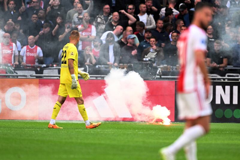 Ajax supporters throw flares onto the pitch during the Dutch Eredivisie soccer match between Ajax Amsterdam and Feyenoord Rotterdam in Amsterdam, the Netherlands, 24 September 2023.   EPA / OLAF KRAAK