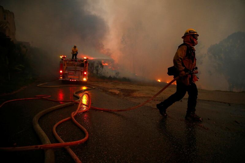 Firefighters battle the Woolsey Fire in Malibu, California, U.S. November 9, 2018. The fire destroyed dozens of structures, forced thousands of evacuations and closed a major freeway. REUTERS/Eric Thayer