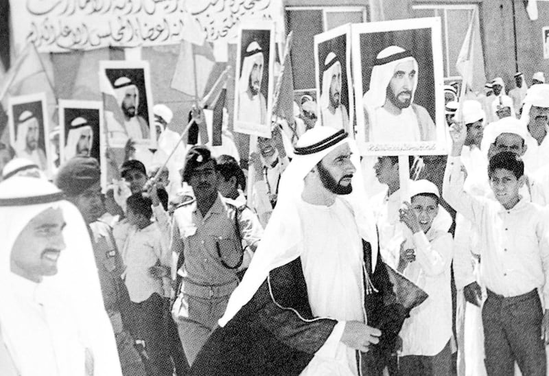 Picture shows President of the United Arab Emirates Sheikh Zayed bin Sultan al-Nahyan walking past supporters receiving him in the emirate of Fujairah  during his visit 03 January 1972. (Photo by WAM / AFP)