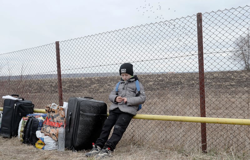 A Ukrainian boy waits for his mother after passing the border crossing point in Siret, northern Romania. EPA