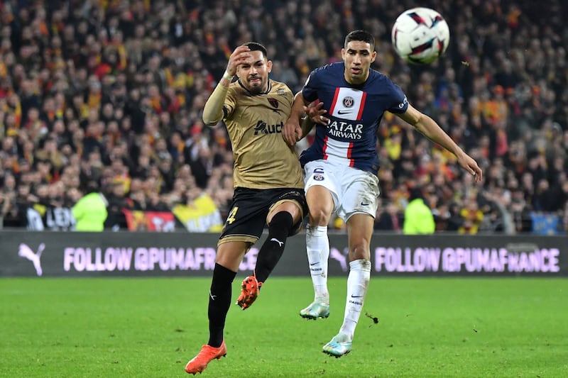 Lens defender Facundo Medina fights for the ball with Paris Saint-Germain's Achraf Hakimi. AFP