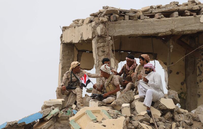 Saudi-backed Yemeni fighters gather above debris of a building while watching the launch by Saudi Development and Reconstruction Programme for Yemen (SDRPY) of multi-million dollar aid projects in the area of Yemen's northern coastal town of Midi, located in conflict-ridden Hajjah governorate near the border with Saudi Arabia. AFP