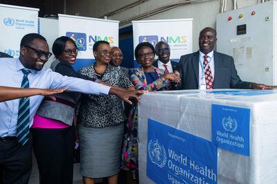 Charles Njuguna (R), of the WHO Country Office in Uganda, and Uganda's Health Minister Jane Ruth Aceng (3rd R) in Entebbe on December 8, as they receive 1200 doses of the Ebola trial vaccine.  AFP