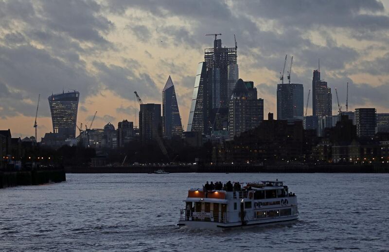 FILE PHOTO: A river boat cruises down the River Thames as the sun sets behind the Canary Wharf financial district of London, Britain, December 7, 2018. REUTERS/Simon Dawson/File Photo  GLOBAL BUSINESS WEEK AHEAD