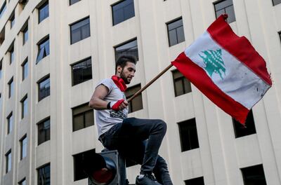 epa07941679 Protester wave Lebanese flags and shout anti-government slogans during a protest in front the Government palace in downtown Beirut, Lebanon, 22 October 2019. Protesters announced they will continue demonstrations and the closure of roads until the resignation of the government and parliament and hold new parliamentary elections one day after Lebanese Prime Minister Saad Hariri announced a series of economic measures adopted by the government and approved the 2020 budget without any new taxes.  EPA/Nabil Mounzer