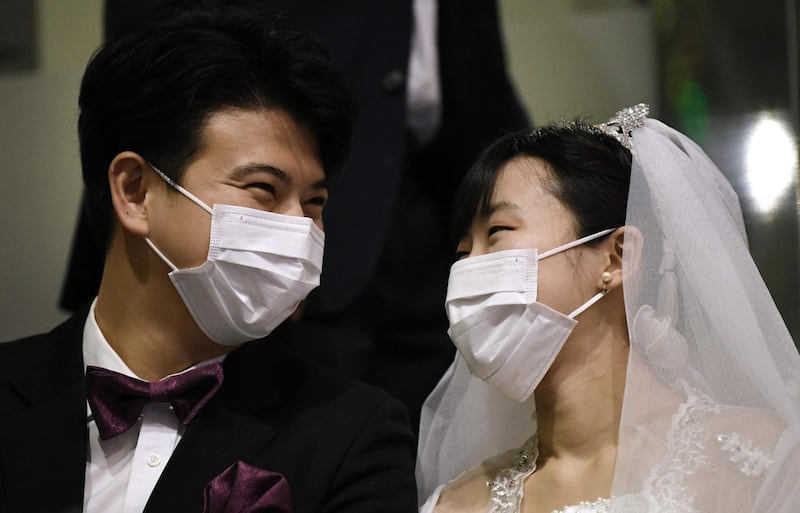 A couple wearing protective face masks attend a mass wedding ceremony organised by the Unification Church at Cheongshim Peace World Center in Gapyeong.  AFP