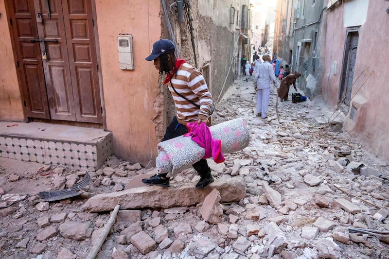 A man walks with his belongings through the rubble in an alleyway in the earthquake-damaged old city in Marrakesh. AFP