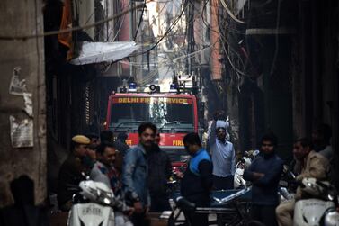 TOPSHOT - A Delhi Fire Service truck is seen along a street near the site of a facotry where a fire broke out, in Anaj Mandi area of New Delhi on December 8, 2019. At least 43 people have died in a factory fire in India's capital New Delhi, with the toll still expected to rise, police told AFP on December 8. The blaze broke out in the early hours in the city's old quarter, whose narrow and congested lanes are lined with many small manufacturing and storage units. / AFP / STR