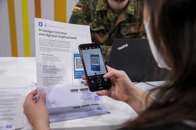 A visitor uses CovPass, Germany's new vaccination passport smartphone app, to scan a QR code after being inoculated at a Covid-19 vaccination center in the Erika-Hess ice rink stadium in Berlin, Germany, on Friday, June 11, 2021. Germany's economy is poised for a strong upswing in the second half of this year, with activity likely to reach pre-crisis levels as soon as this summer, the Bundesbank said. Photographer: Krisztian Bocsi/Bloomberg