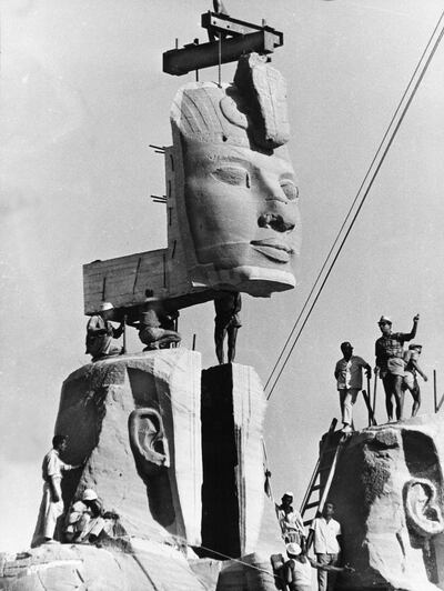 FILE - In this photo taken on Oct. 11, 1966 in Egypt, workmen lower one of the heads of the four rock-hewn colossi of King Ramses II into place, on the foundation of the re-sited monument. The global campaign that saved the ancient Egyptian temples of Abu Simbel from inundation by the Aswan Dam 50 years ago was remembered this week as an unprecedented engineering achievement and a turning point in the perception of cultural treasures as a responsibility of all humanity. (AP Photo)