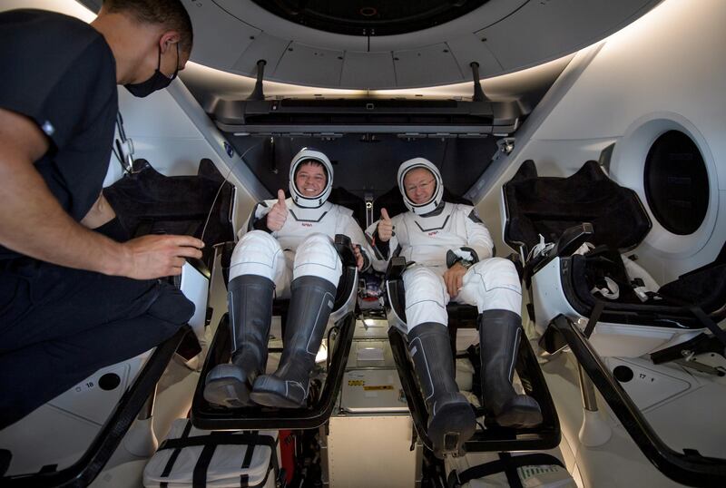 NASA astronauts Robert Behnken, left, and Douglas Hurley are seen inside the SpaceX Crew Dragon Endeavour spacecraft onboard the SpaceX GO Navigator recovery ship shortly after having landed in the Gulf of Mexico off the coast of Pensacola, Florida, U.S. REUTERS