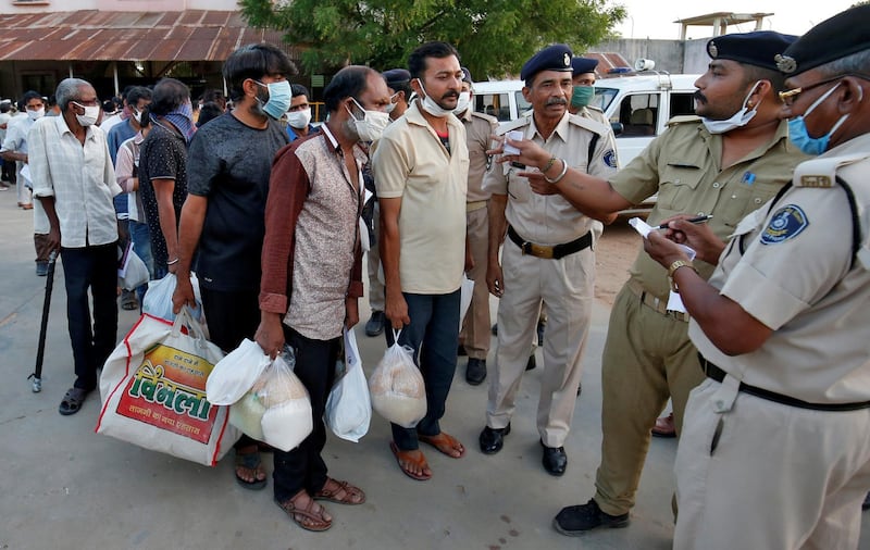 Police officers speak with prisoners after they were released on parole outside the Sabarmati Central Jail during a 21-day nationwide lockdown to slow the spreading of coronavirus disease (COVID-19), in Ahmedabad, India. REUTERS