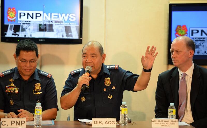 Gilbert Sosa, chief of the Philippines police cybercrime division, centre, addresses a press conference at the police headquarters in Manila on May 2, 2014, to announce the arrest of 58 people for their involvement in a global Internet “sextortion” network.  Ted Aljibe / AFP