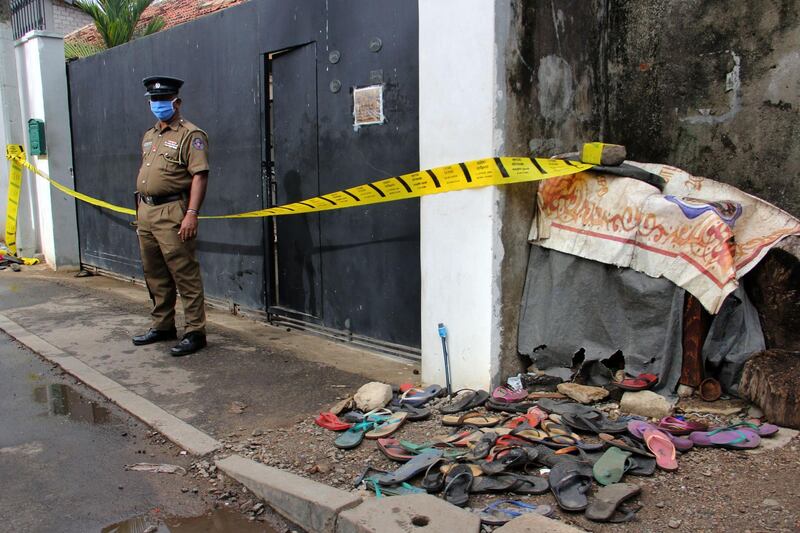 A policeman stands guard outside a house in Colombo after three women were crushed to death during a cash distribution for residents affected by the coronavirus lockdown. AFP