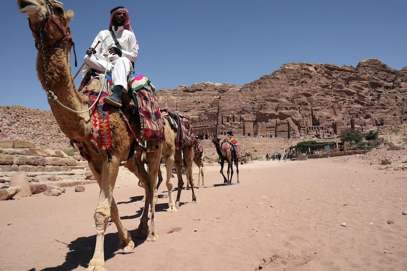 A Jordanian leads a caravan of camels in Jordan's ancient city of Petra on May 5, 2017. 
Established as the capital city of the Nabataeans, the rose rock city is Jordan's most popular touristic site and was chosen as one of the seven New Wonders of the World in 2007. / AFP PHOTO / THOMAS COEX