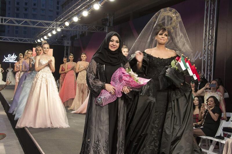 UAE designer Mona Al Mansouri, centre, appears on the catwalk next to models wearing her creations at the end of her show during the Summer Fashion Week at the Saint Georges Hotel in Beirut. Nabil Mounzer / EPA