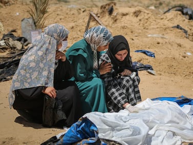 (EDITORS NOTE: Image depicts death. ) Palestinian women mourn beside a body recovered from a mass grave at the Nasser Medical Hospital compound in Khan Younis, southern Gaza, on Sunday, April 21, 2024.  More than 34,000 Palestinians have died, according to the Hamas-run health authority. Photographer: Ahmad Salem / Bloomberg