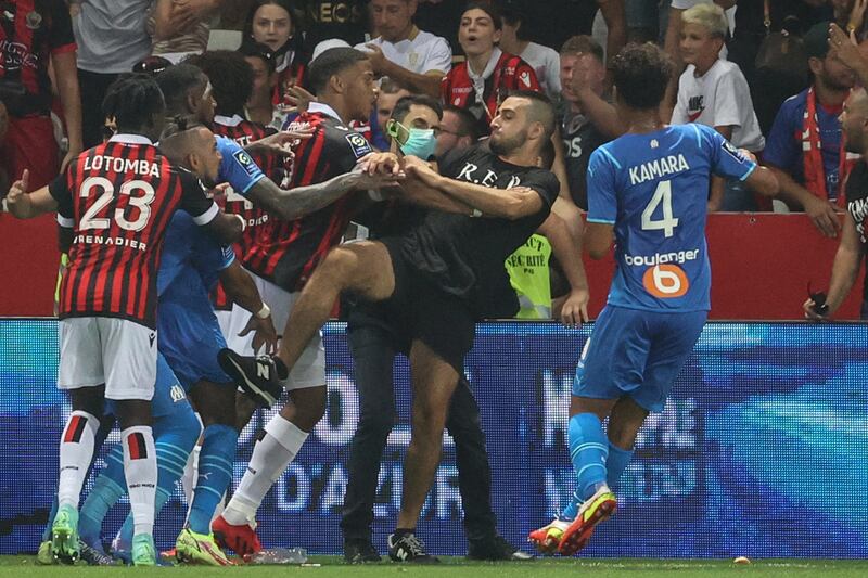 A fan attacks Marseille player Dimitri Payet (in blue) during the Ligue 1 game against Nice at the Allianz Riviera stadium on Sunday, August 22. The match was abandoned after Marseille refused the finish the game saying they feared for players' safety. AFP