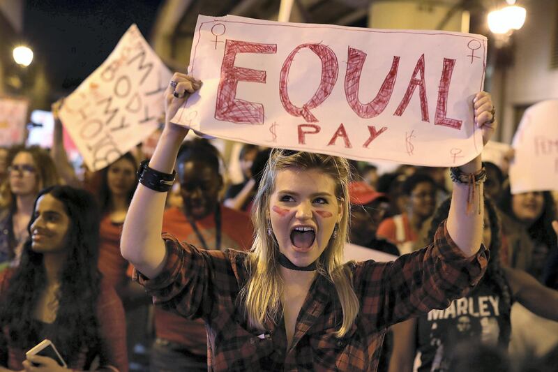 MIAMI, FL - MARCH 08:  Clarissa Horsfall holds a sign reading, 'Equal Pay,' as she joins with others during 'A Day Without A Woman' demonstration on March 8, 2017 in Miami, United States. The demonstrators were calling for woman to have equity, justice and human rights for women and all gender-oppressed people.  (Photo by Joe Raedle/Getty Images)