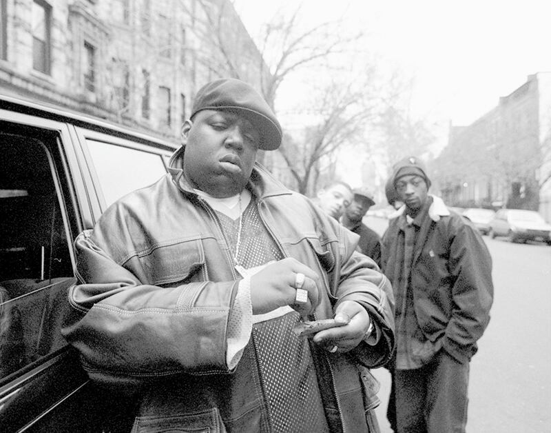 American rapper Notorious B.I.G., aka Biggie Smalls, aka Chris Wallace (1972 - 1997), rolls a cigar outside his mother's house in Brooklyn, New York, 18th January 1995.  (Photo by Clarence Davis/NY Daily News Archive via Getty Images)