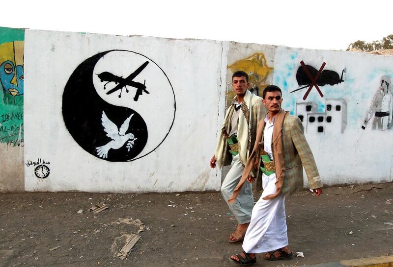 Men walk by a mural of a US drone and a dove in a yin-yang symbol in Sanaa, Yemen. In The Angel of History by Rabih Alameddine we learn about the adventures of a drone that crash lands in Yemen. Mohammed Huwais / AFP