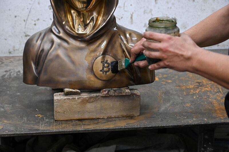 The bust emblazoned with a Bitcoin symbol gets a wax coating