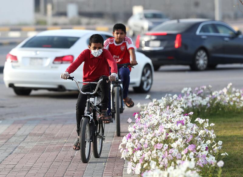 A boy wears a protective face mask as he rides a bicycle in Qatif, Saudi Arabia. Saudi Arabia imposed quarantine measures on the province of Qatif, following the spread of coronavirus. Reuters