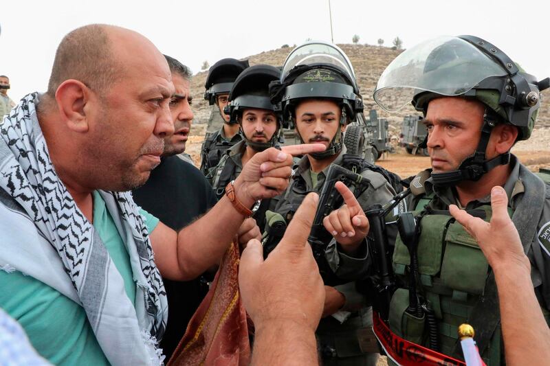 A Palestinian protester argues with an Israeli border policeman during a protest against the confiscation of lands in the village of Surif, northwest of the West Bank city of Hebron.  AFP