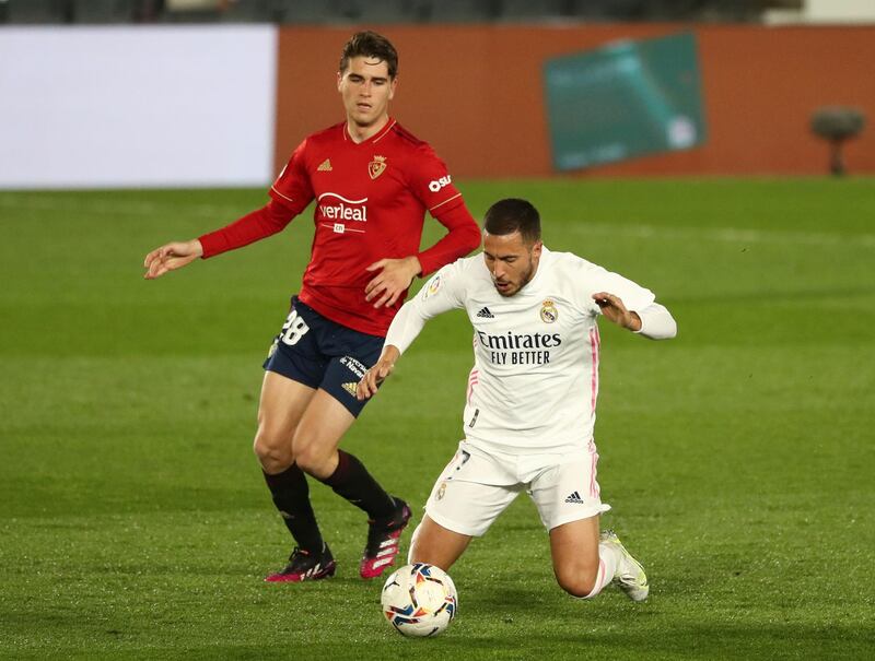Real attacker Eden Hazard goes down under pressure from Osasuna's Javi Martinez. Reuters